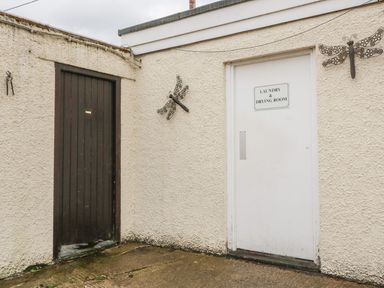 A laundry room entrance with a sign at Cottage No 9 in Keswick