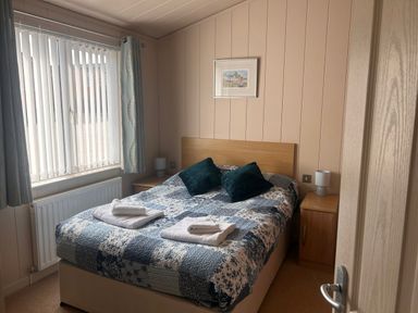 A bedroom with a bed and bedside tables at 1 Ocean Terrace, Mullacott near Ilfracombe