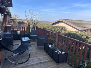 An outdoor seating area with chairs and table at 1 Ocean Terrace in Mullacott near Ilfracombe