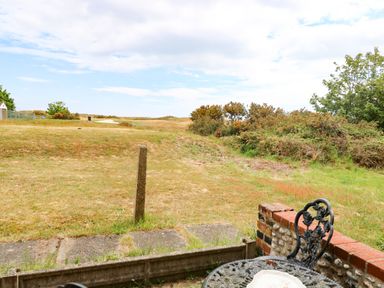 A garden view with grass and bushes at Mabby, Great Yarmouth