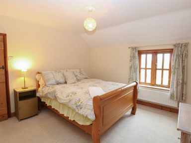 A bedroom with a bed and window at Mabby in Caister-On-Sea