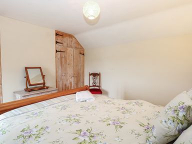 A bedroom with a bed and mirror at Mabby in Caister-On-Sea