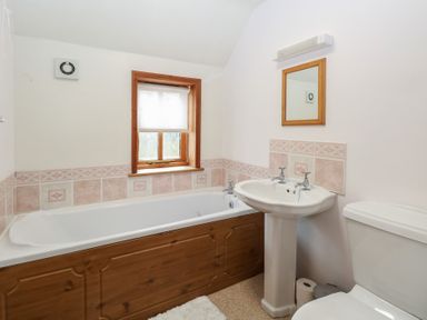 A bathroom with a bath tub, sink, and toilet at Mabby in Caister-On-Sea