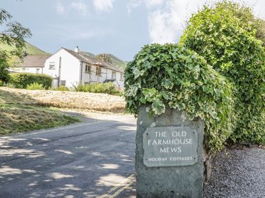 A sign indicating The Old Farmhouse Mews holiday cottages at Keswick