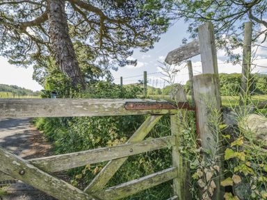 An outdoor scene featuring a wooden gate and a signpost at No 8- Farmhouse Retreat in Keswick