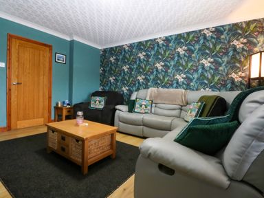 A living room with a sofa and coffee table at 36 Cae Rhos in Holyhead