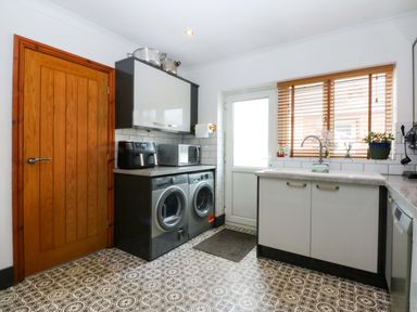 A kitchen with a washing machine and dryer at 36 Cae Rhos in Holyhead