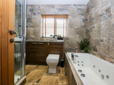 A bathroom with a bathtub and shower at 36 Cae Rhos in Holyhead