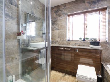 A bathroom with a shower, toilet and sink at 36 Cae Rhos, Holyhead