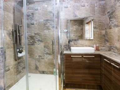 A bathroom with a shower and sink at 36 Cae Rhos in Holyhead