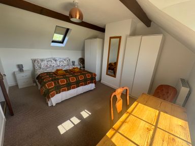A bedroom with a bed and table at Penpegws near Aberystwyth