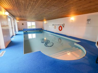 An indoor pool with steps and a lifebuoy at Cliff Cottage