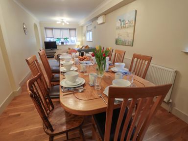 A dining room with a table set for a meal at Cliff Cottage