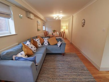 A living room with a sofa and dining area at Cliff Cottage