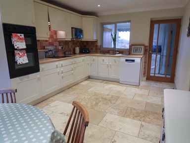 A kitchen with cabinets and appliances at Cliff Cottage