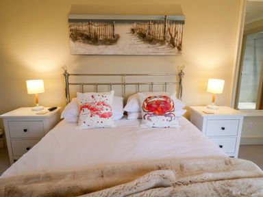 A bedroom with a bed and two bedside lamps at Cliff Cottage 