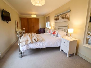A bedroom with a bed and nightstand at Cliff Cottage 