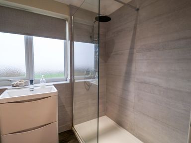 A bathroom with a shower and wash basin at Cliff Cottage