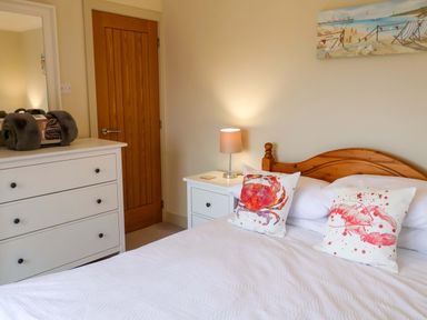 A bedroom with a bed and a dresser at Cliff Cottage