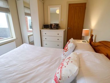 A bedroom with a bed and dresser at Cliff Cottage