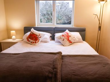 A bedroom with a bed and lamp at Cliff Cottage