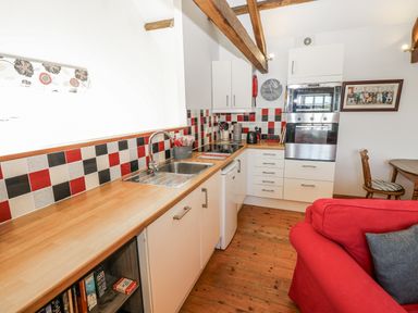 A kitchen with cabinets and appliances at Dove Cottage in Hexham