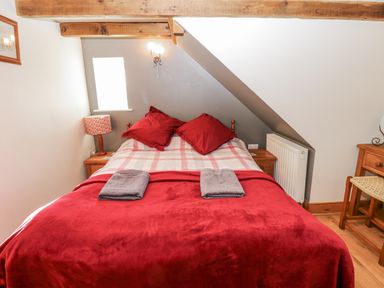 A bedroom with a bed and furniture at Dove Cottage in Hexham