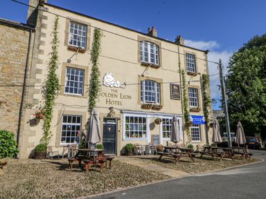 An outdoor patio with tables and umbrellas at The Golden Lion Hotel in Hexham