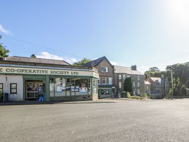 A co-operative society storefront with nearby buildings at Dove Cottage in Hexham