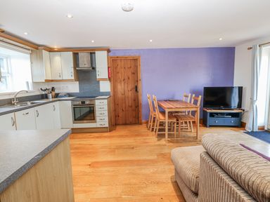 A kitchen with dining area and television at Swallows Rest in Hexham