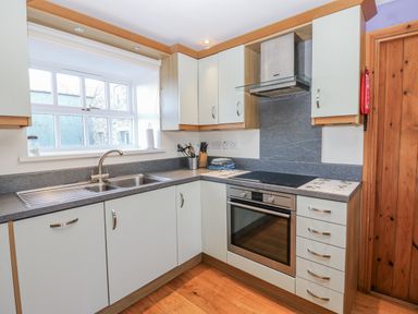 A kitchen with cabinets and a stove at Swallows Rest in Hexham
