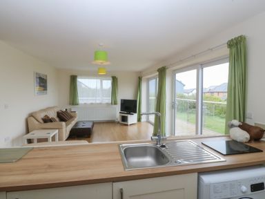 A living room with a sofa and television at Orme View in Penmaenmawr
