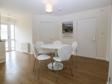 A dining room with a table and chairs at Orme View in Penmaenmawr