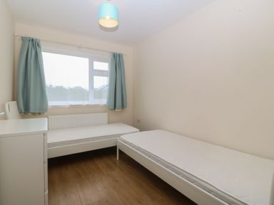 A bedroom with two beds and a window at Orme View in Penmaenmawr