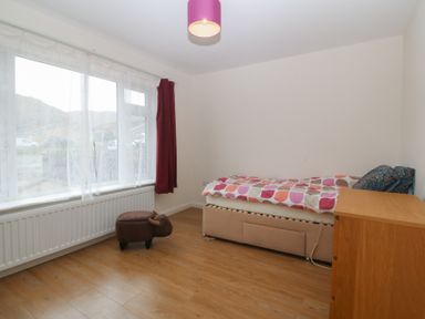 A bedroom with a bed and a window at Orme View in Penmaenmawr