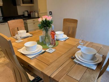 A dining table set with plates and glasses at Tiggywinkle Beck - White Cross Bay, Windermere