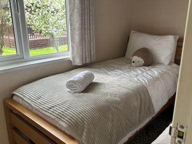 A single bed with a pillow and towel in a bedroom at Tiggywinkle Beck - White Cross Bay Windermere