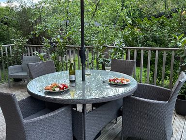 An outdoor dining area with a table and chairs at Tiggywinkle Beck - White Cross Bay Windermere