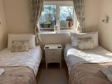 A bedroom with two beds and a window at Owls House - White Cross Bay in Windermere