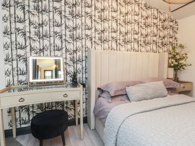 A bedroom with a bed and vanity table at Caban Tan Y Ffawydd in Chwilog near Y Ffor