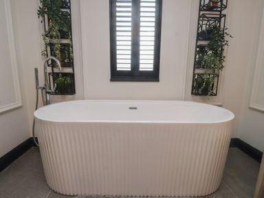 A bathroom with a bathtub and plants on a shelf at Caban Tan Y Ffawydd in Chwilog near Y Ffor