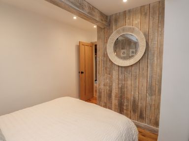 A bedroom with a bed and a mirror at Riverside Lodge Afonwen