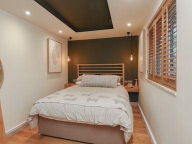 A bedroom with a bed and bedside table at Riverside Lodge Afonwen