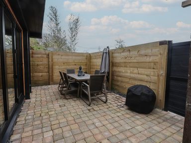 An outdoor patio with a table and chairs at Riverside Lodge Afonwen
