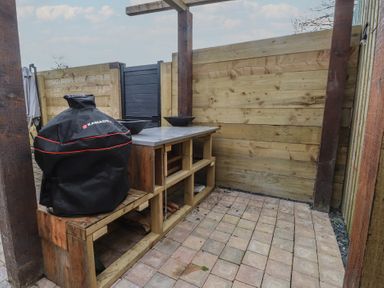 An outdoor kitchen with a grill and worktop at Riverside Lodge Afonwen