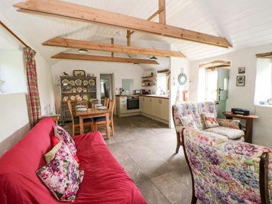A living room with a sofa and dining area at Rhos Y Clegyrn Goodwick