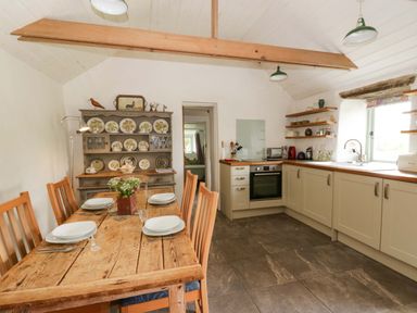 A kitchen with a dining table and chairs at Rhos Y Clegyrn in Goodwick
