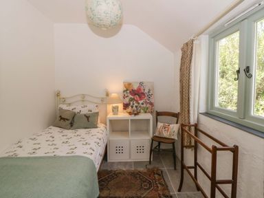 A bedroom with a bed and a chair at Rhos Y Clegyrn Goodwick