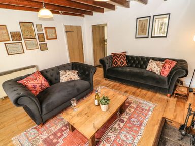 A living room with sofas, a coffee table, and decorative items at Englewood Cottage Hexham