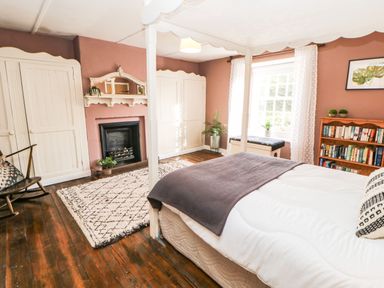 A bedroom with a bed and bookshelf at Englewood Cottage in Hexham